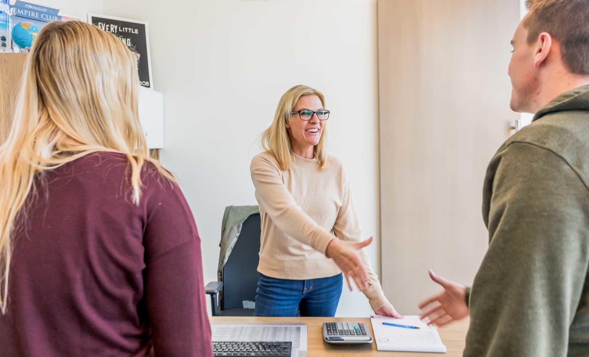 An Edge homes agent shaking hands with potential home-buyers.