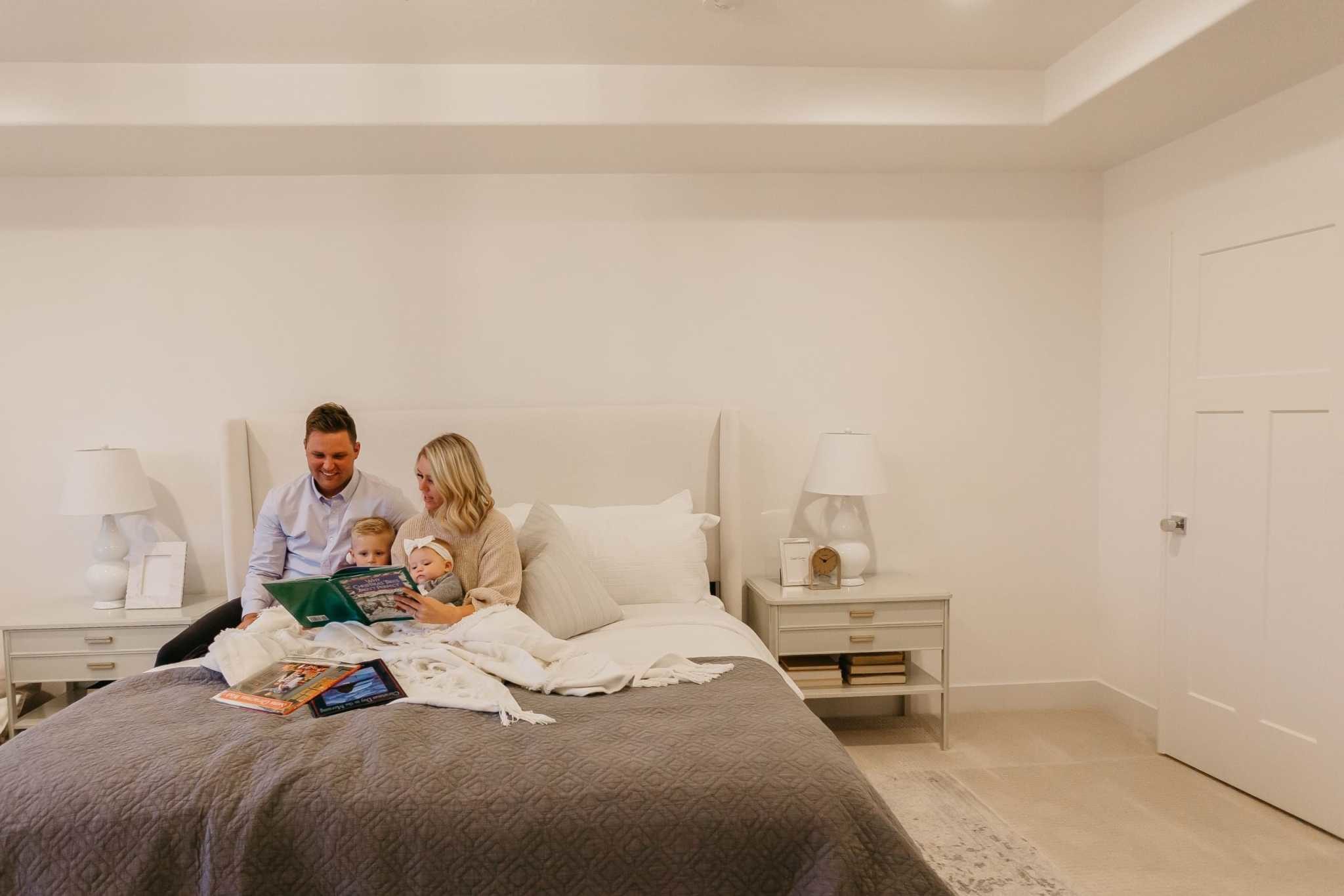 Young family reading story in bed