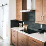 Extra counter space with charcoal backsplash with light wood cabinets