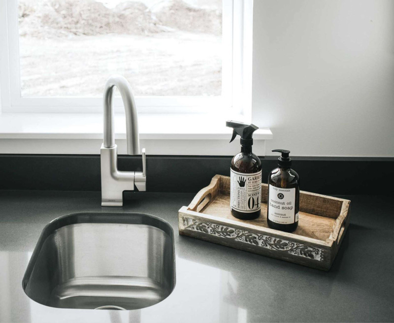 small hand-washing sink with window and tray of hand soaps