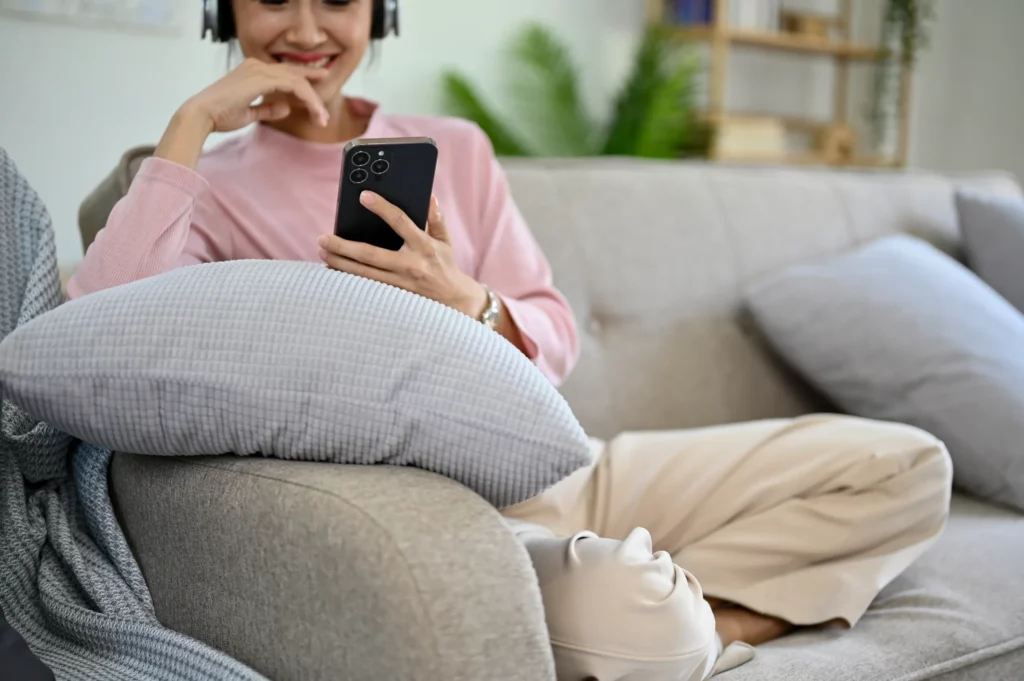 A woman listens to the best real estate podcast on her phone.