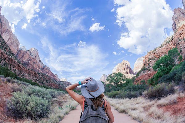 Woman with hat on hiking in Utah’s desert on one of their various spring trails
